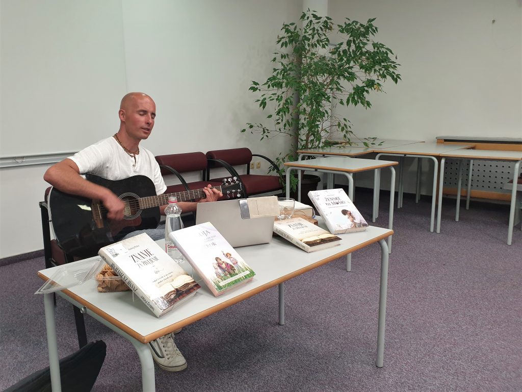 Andrej Pešec s kitaro ob glasbenem zaključku predavanja z mantranjem